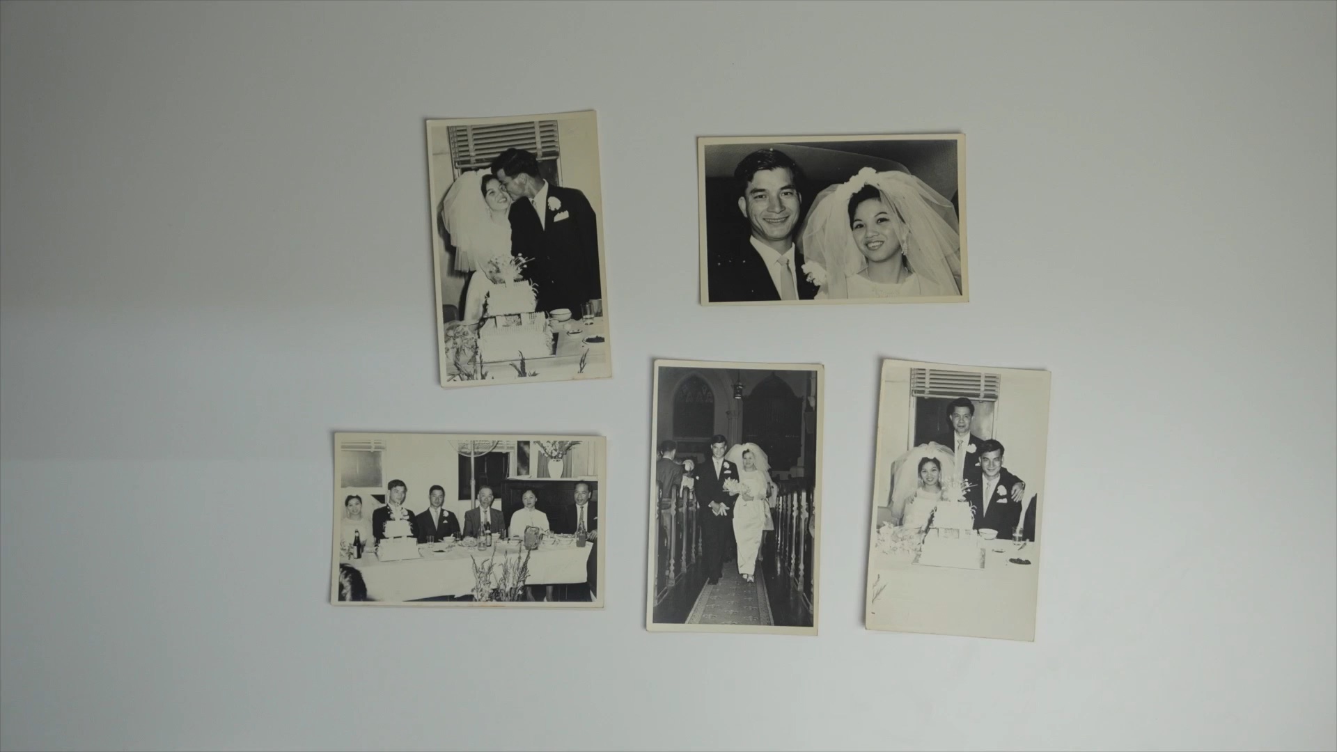 Old family wedding photographs arranged on a wall