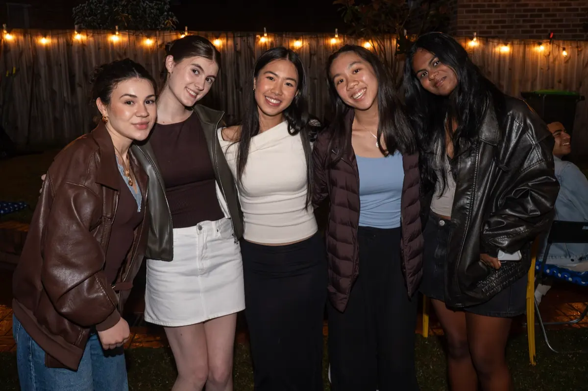 Group photo at a backyard party under string lights